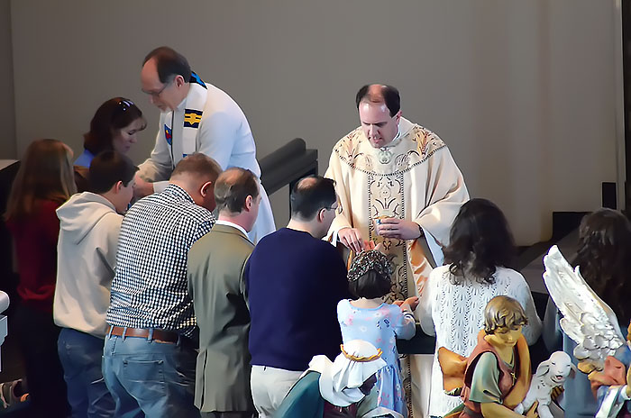 Dr. Kent J. Burreson, dean of the Chapel of St. Timothy and St. Titus at Concordia Seminary, offers Holy Communion during  an Epiphany service in January 2015.