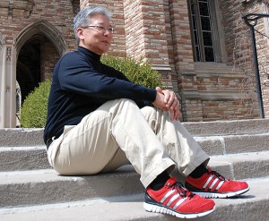 Dr. Joel Okamoto sports his trademark red sneakers on the steps outside of Luther Tower.